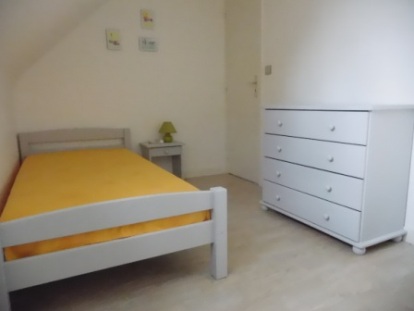 photo chambre jaune avec 2 lits d'une place.
